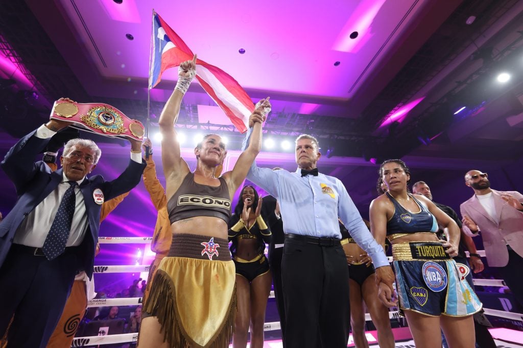 Amanda Serrano has her hand raised after her victory over Lucrecia Manzur is announced in the ring.