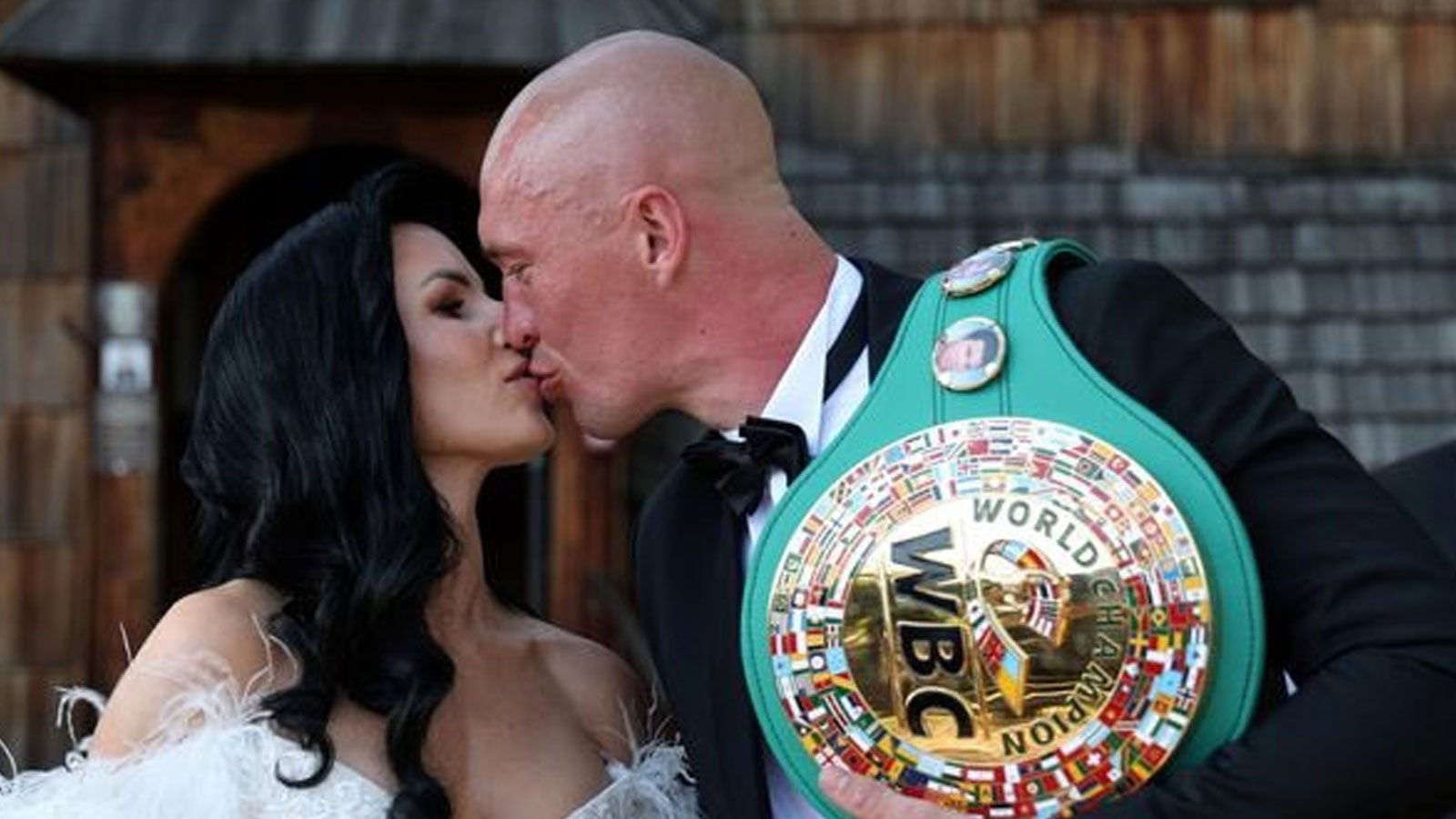 Michal Cieslak kisses his new wife while holding his WBC interim Cruiserweight belt during their wedding celebrations.